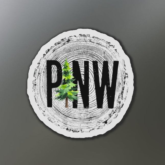 Round sticker with 'PNW' and tree design on a refrigerator