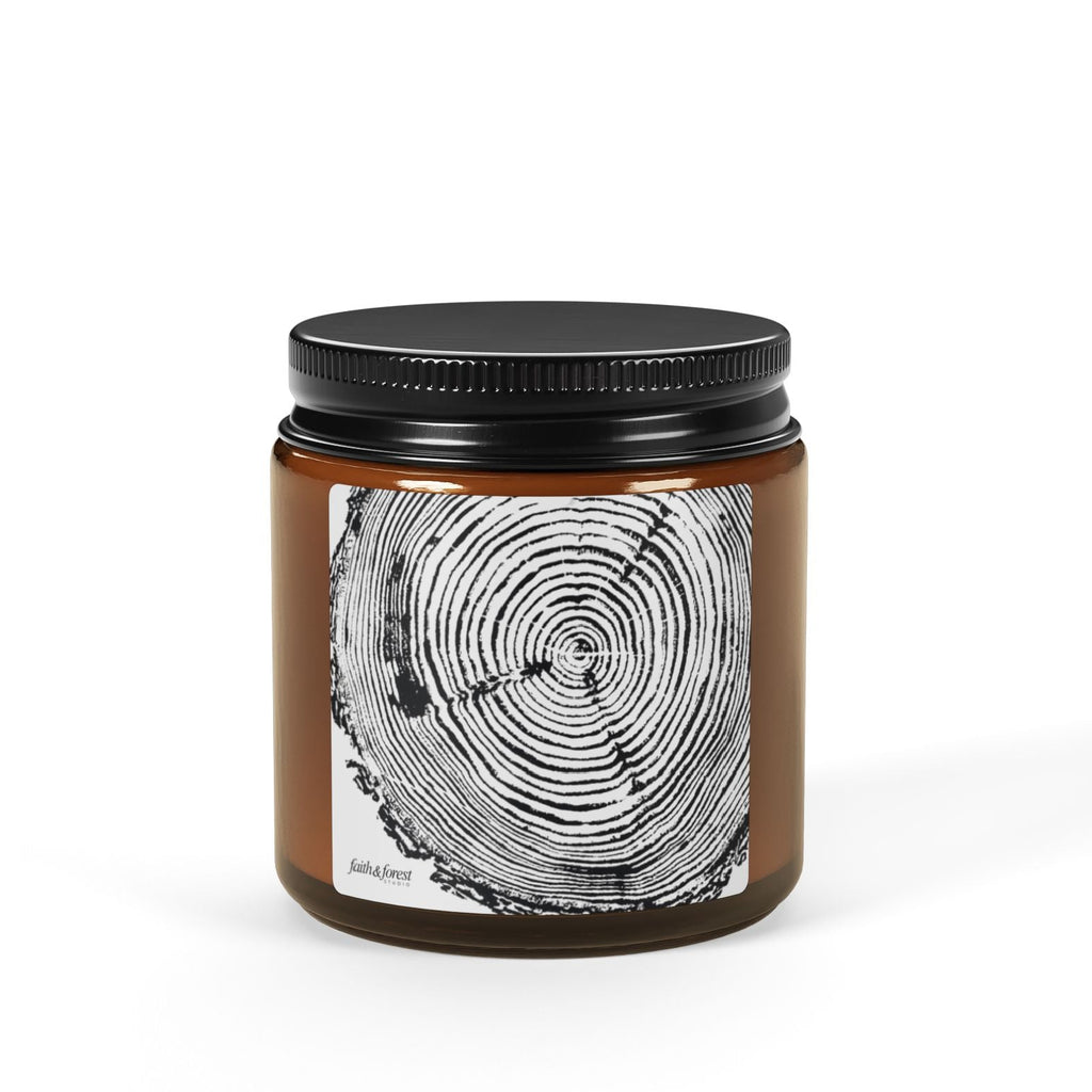 Candle jar with black lid and tree ring design on a white background